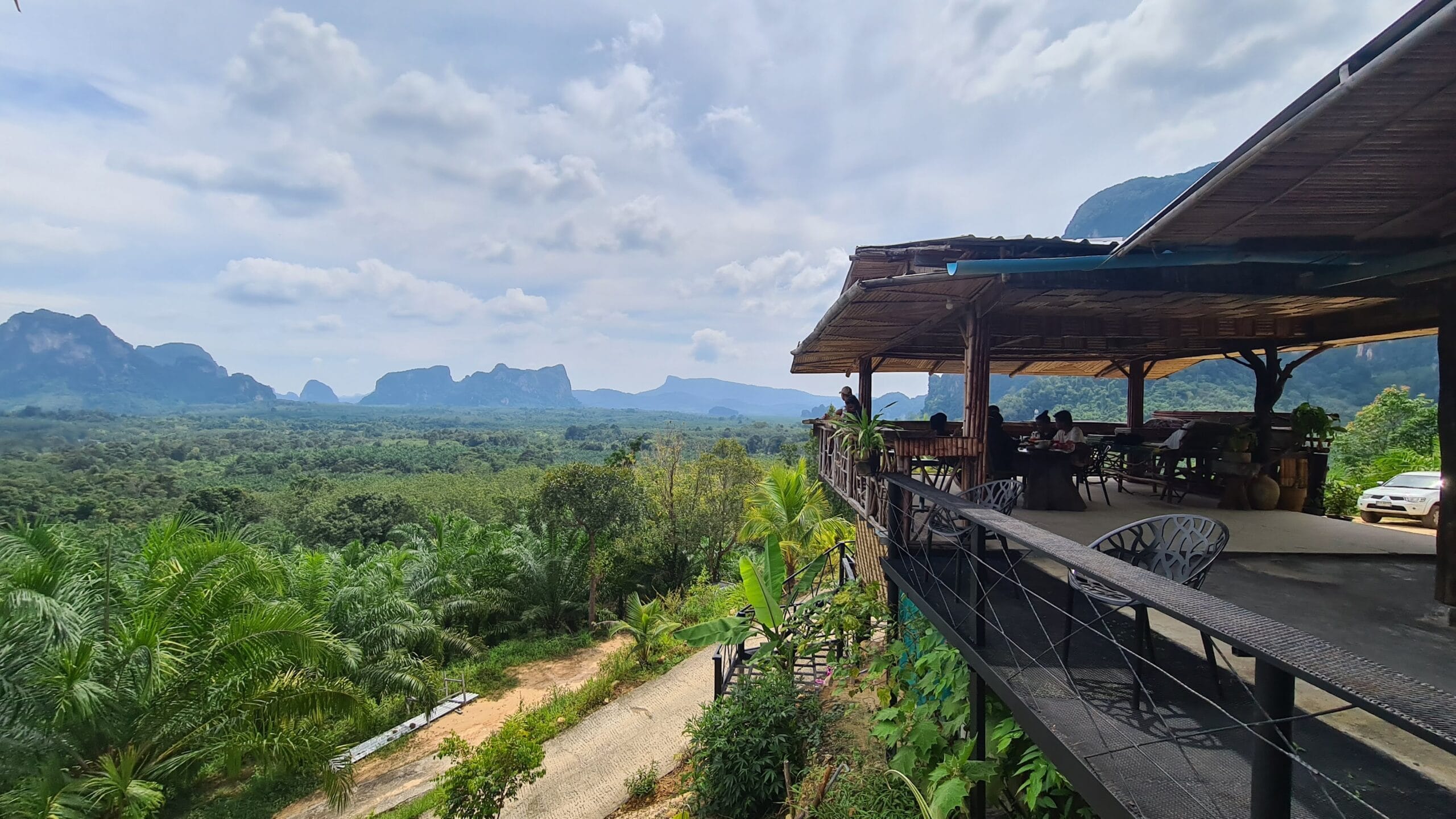 Inland restaurant terrace overlooking green Krabi countryside and limestone mountains