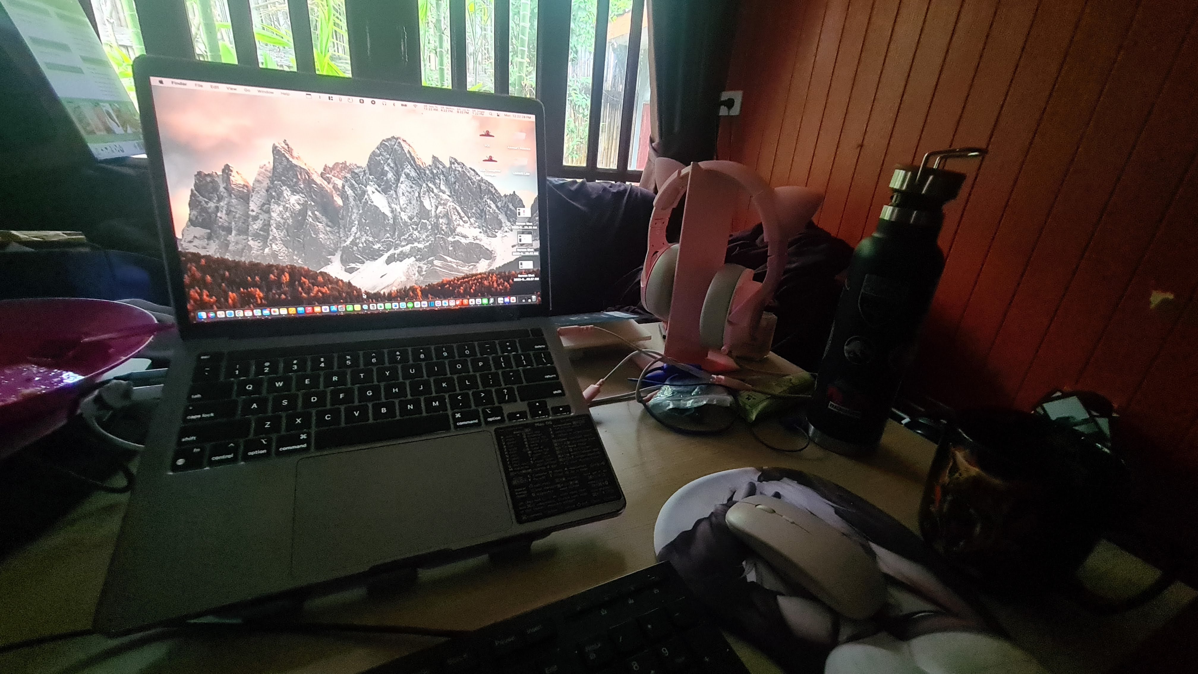 Laptop, headphones and cables on a real remote-work desk in Thailand