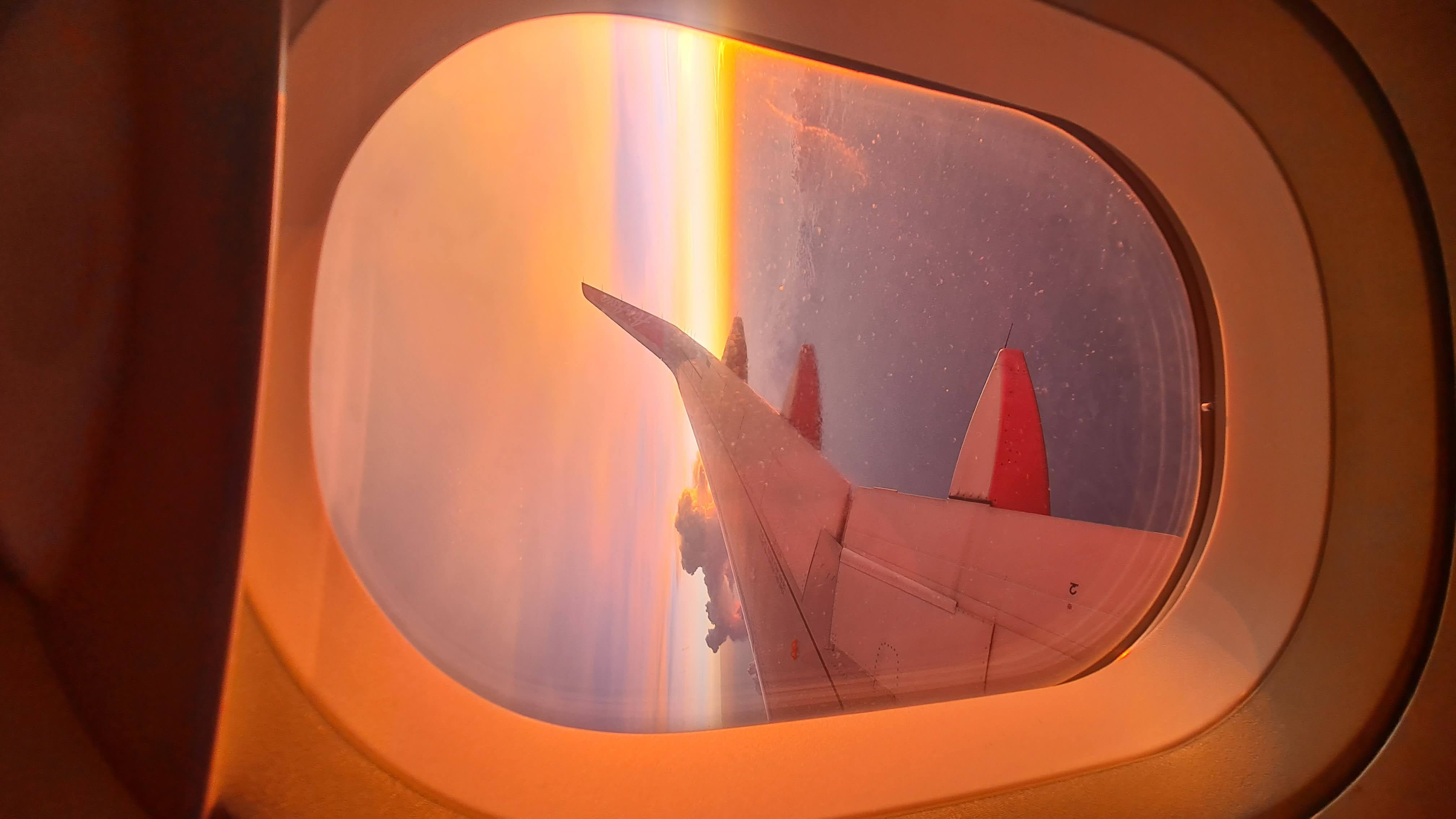Airplane wing at sunset during international travel