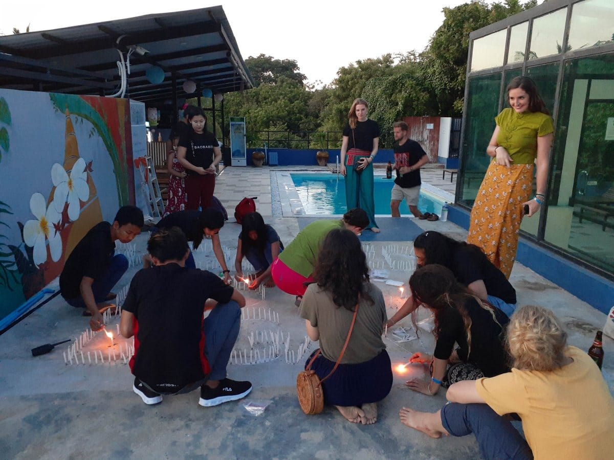 Travelers and hostel guests arranging candles for Thadingyut in Myanmar