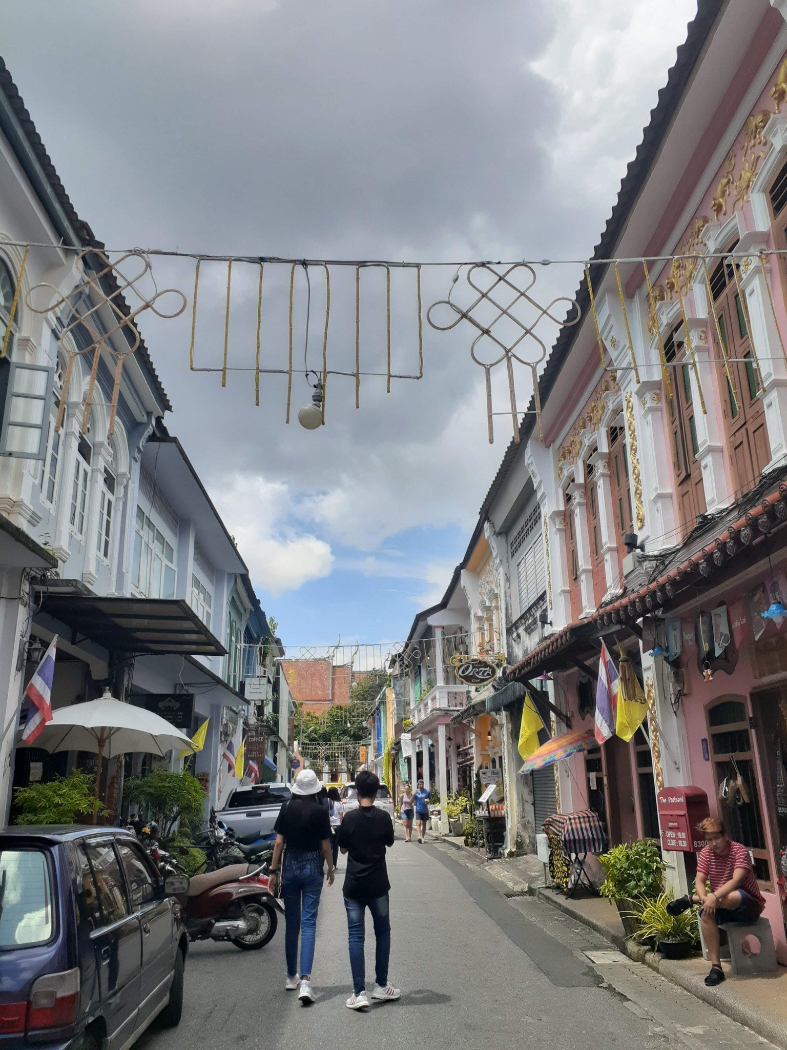 Colorful historic shophouses and pedestrians on a street in Phuket Town in 2019