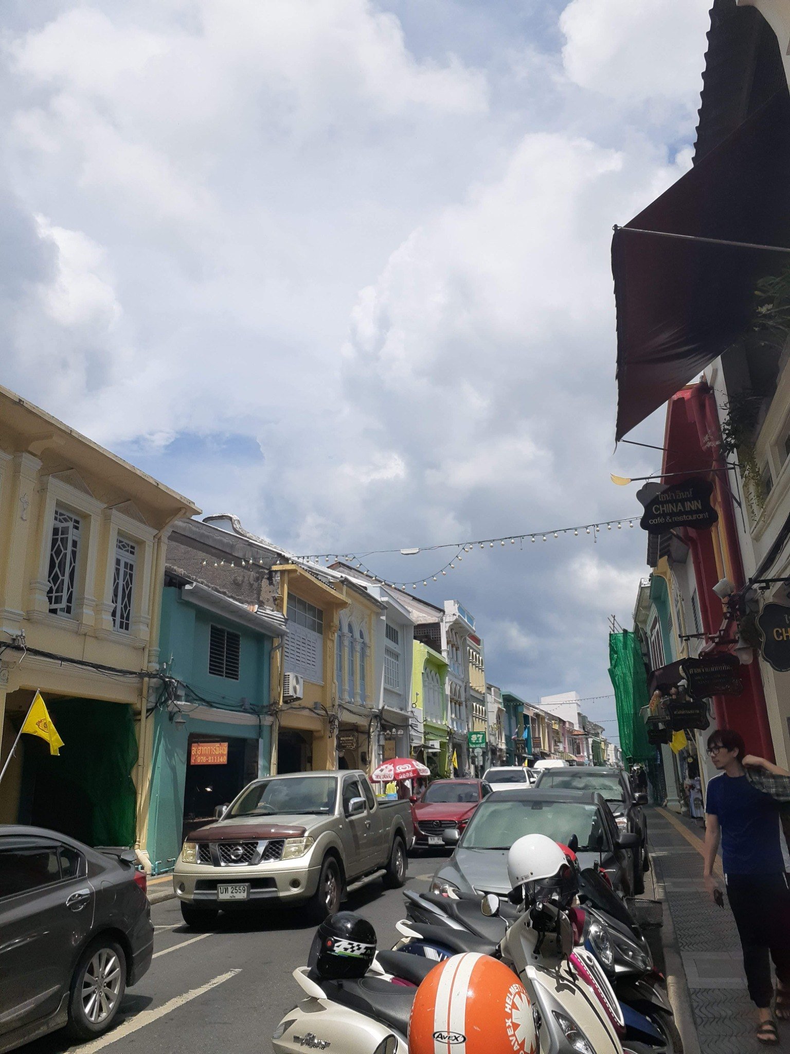 Traffic, scooters and colorful buildings on a street in Phuket Town in 2019