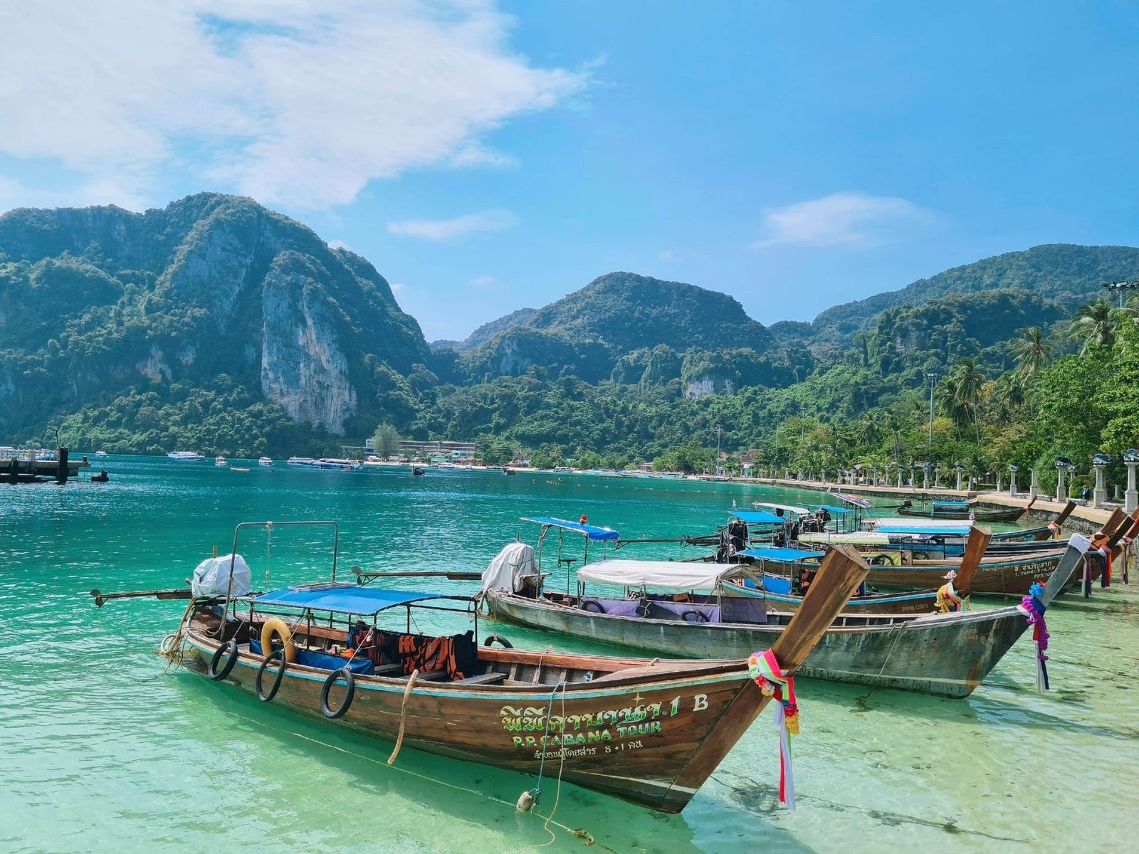 Longtail boats on turquoise water in southern Thailand during a normal work week