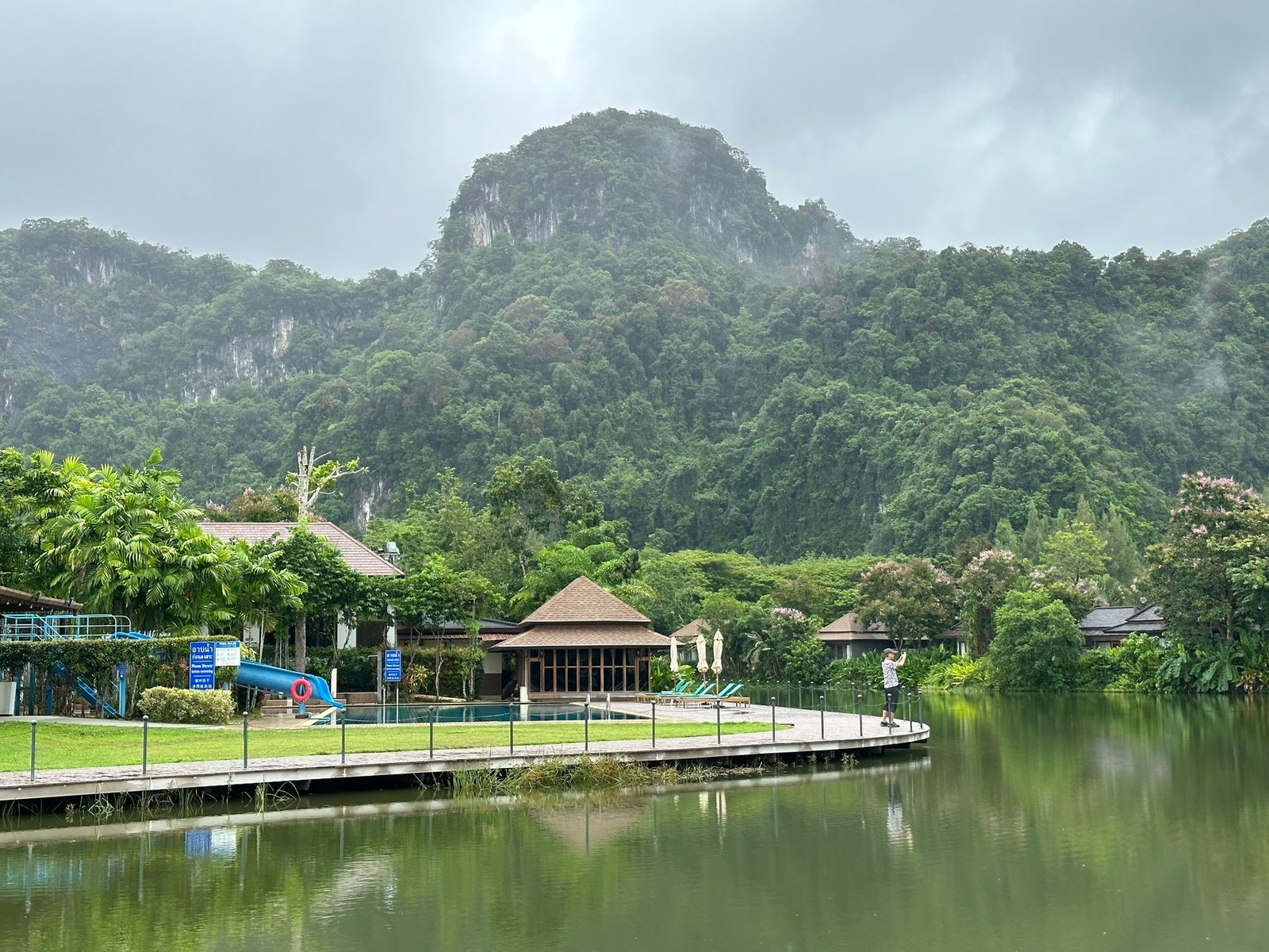 Green limestone mountains and a lakeside property in Thailand during a normal teaching work week