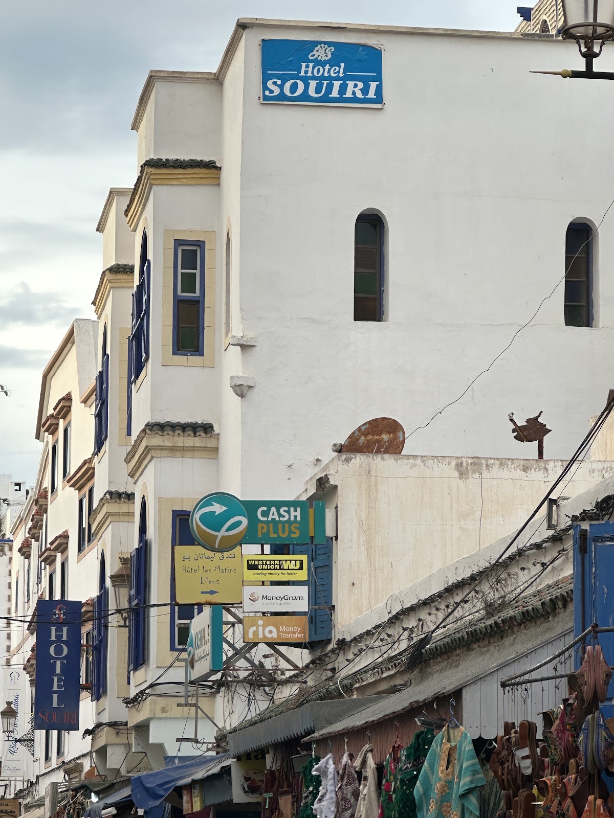 Everyday city street with hotel, money transfer and local business signs