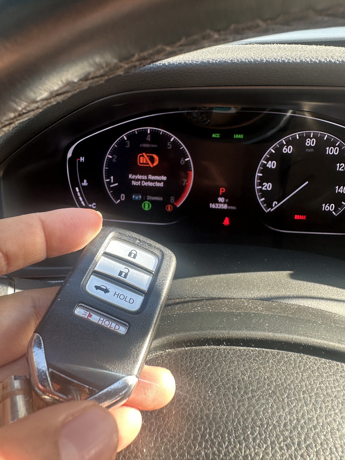 Car key fob held in front of a dashboard displaying Keyless Remote Not Detected